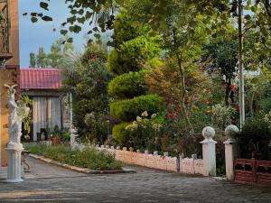 a fence in front of a garden with trees at SeGi Garden Home in Khobi