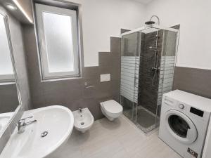 a bathroom with a sink toilet and a washing machine at Apartment Federico in Melfi