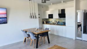 a dining room with a table and chairs in a kitchen at Apartament C22 in Darłowo +17 photos