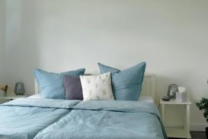 a bed with blue and white pillows on it at Ferienwohnung Calluna in Faßberg +9 photos