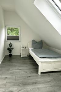 a white room with a bed and a window at Ferienwohnung Calluna in Faßberg