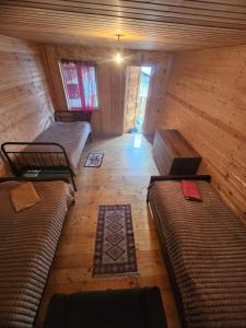 a room with several beds in a wooden cabin at guest house "BETQIL" adishi in Adishi