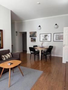 a living room with a couch and a table and chairs at Maironis - Spacious Apartment in the Heart of Kaunas in Kaunas