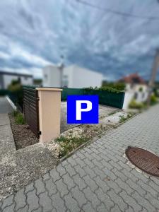 a blue parking sign on the side of a sidewalk at Apartmán Zamarovce in Trenčín