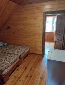 a bedroom with a bed in a wooden cabin at Akacia in Svityazʼ