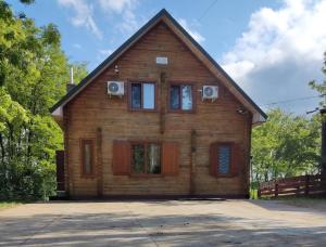 a wooden house with a gambrel roof at Akacia in Svityazʼ