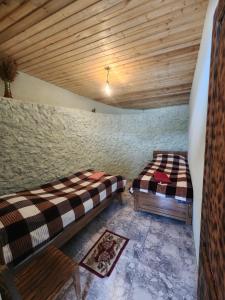 two beds in a room with a wooden ceiling at guest house "BETQIL" adishi in Adishi