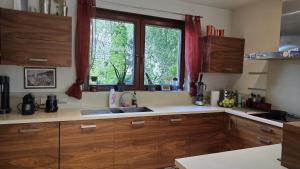 a kitchen with wooden cabinets and a sink and a window at sPokój na Marsa in Straszyn +8 photos