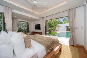 a bedroom with a large bed and a swimming pool at Grand garden villa Free Airport Pickup from 7 days in Phuket