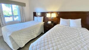 a hotel room with two beds and a window at Royal Inn Hotel in Royal Palm Beach +43 photos