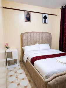 a bedroom with a large bed with white sheets at Nyeri 1 Bedroom BnB in Nyeri