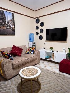 a living room with a couch and a flat screen tv at Nyeri 1 Bedroom BnB in Nyeri