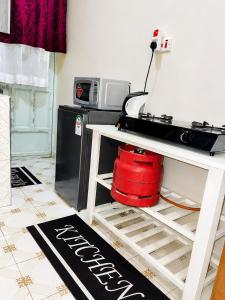 a kitchen with a white table and a microwave at Nyeri 1 Bedroom BnB in Nyeri +2 photos