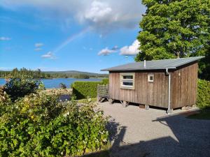 a small wooden cabin with a solar roof on a lake at Attefallshus på Långnäs in Bollnäs