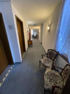 an empty hallway with two chairs and a window at Hotel Garni Ratstube in Bad Urach