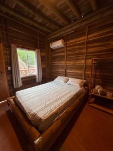 a bed in a wooden room with a window at Greengoat Haven in Santa Marta