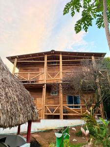 a wooden building with flamingos in front of it at Greengoat Haven in Santa Marta