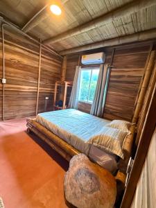 a bed in a wooden room with a window at Greengoat Haven in Santa Marta