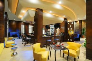a lobby with yellow chairs and a bar at Houston Marriott Energy Corridor in Houston