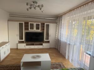 a living room with a tv and a large window at Cosy accommodation in Dańce