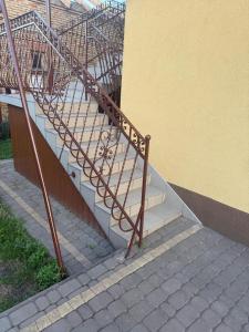 a staircase with a metal railing next to a building at Cosy accommodation in Dańce