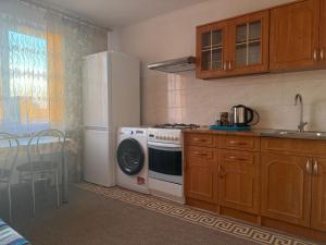 a kitchen with a refrigerator and a washing machine at Cosy accommodation in Dańce +2 photos