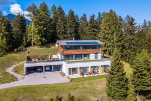 an aerial view of a house on a hill with trees at Bed and Breakfast Raschainas Lenzerheide in Sporz