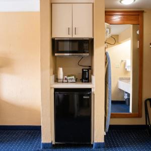 a kitchen with a black dishwasher in a hotel room at Hatteras Island Inn in Buxton
