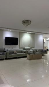 a living room with couches and a flat screen tv at فلة وشاليه ابحر الشمالية in Jeddah