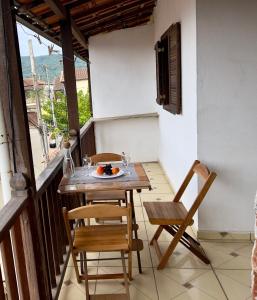 a table and chairs on the balcony of a house at Reis Family Paraty - Suíte Privativa Nova e Funcional com Varanda in Paraty