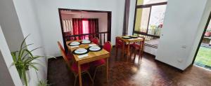 a dining room with two tables and red chairs at Casa TIANA in Mindelo