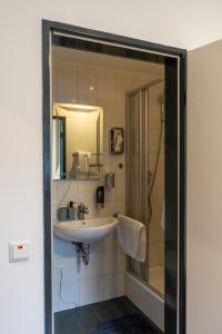 a bathroom with a sink and a shower with a mirror at Restaurant Hotel Friesdorfer Hof in Bonn +19 photos