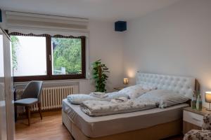 a bedroom with a bed and a chair and a window at Restaurant Hotel Friesdorfer Hof in Bonn