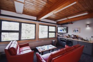 a living room with two red chairs and a table at Seward Adventure Lodge in Seward