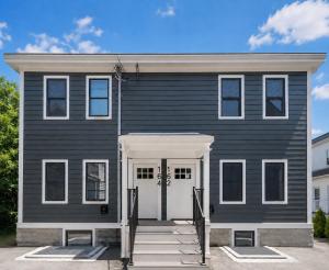 a blue house with a white door and a porch at Harvard Charm Near Boston New build in Cambridge