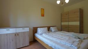 a bedroom with a large bed and a wooden cabinet at Villa Palazzo Apartments in Siófok