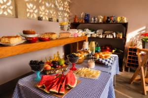 a table with fruits and other foods on it at Villa Pella - Chalé Rosa- hidro e café manhã in Brumadinho +2 photos