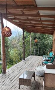 a patio with a table and chairs on a wooden deck at Domos y Cabañas Antu Mahuida in Melipeuco