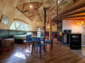 a room with a bed and a table and chairs at Domos y Cabañas Antu Mahuida in Melipeuco