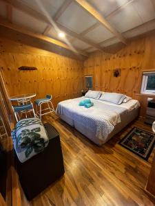 a bedroom with a bed and two chairs in it at Domos y Cabañas Antu Mahuida in Melipeuco +31 photos