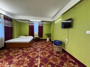 a bedroom with a bed and a flat screen tv at The Mirik Address in Mirik
