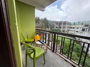 a balcony with chairs and a table and a view at The Mirik Address in Mirik
