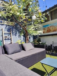 a couch sitting on the grass in a yard with a tree at Le Cocon des Hortillonnages d'Amiens in Camon