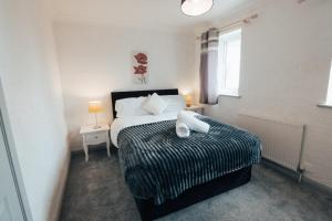 a bedroom with a bed and two lamps and a window at Dinorben Retreat in Amlwch