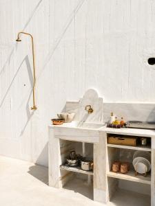 a white kitchen with a counter and a sink at THE HILL Suite in Ialysos