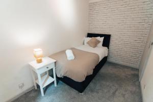 a small bedroom with a bed and a night stand at Dinorben Retreat in Amlwch