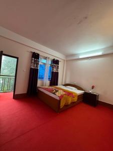 a bedroom with a bed and a red carpet at The Mirik Address in Mirik +5 photos