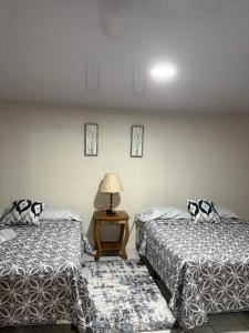 two beds in a room with a lamp on a table at Beach House EL Cocalito in La Libertad +34 photos