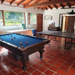 a pool table in a room with two ping pong tables at Hacienda San Pedro Claver Subachoque in Subachoque