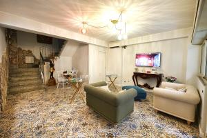 a living room with two couches and a tv at Tao chambre in Taormina